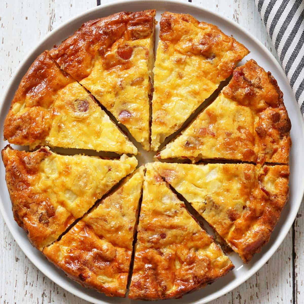 A crustless quiche Lorraine is served on a plate.