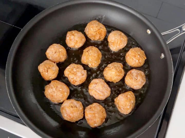 Browning the meatballs in a skillet.