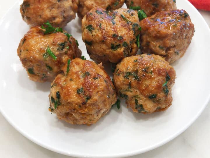The meatballs are served on a white plate.