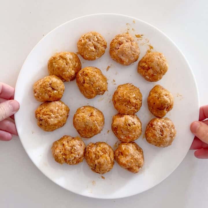 The meatballs were shaped and placed on a white plate.