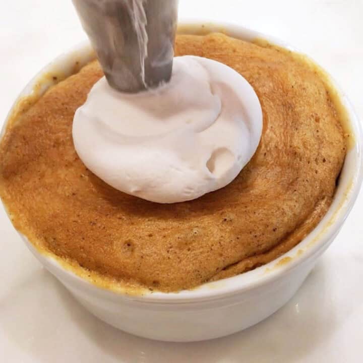 Topping the cake with whipped cream.