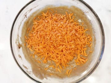 Adding shredded carrots to the batter.