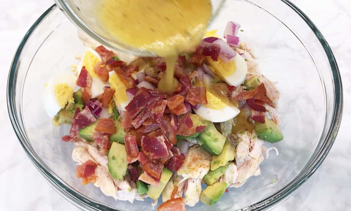 Adding dressing to the salad.