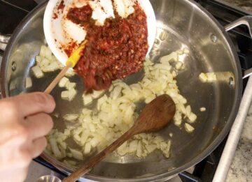 Adding the seasoning paste to the pan.