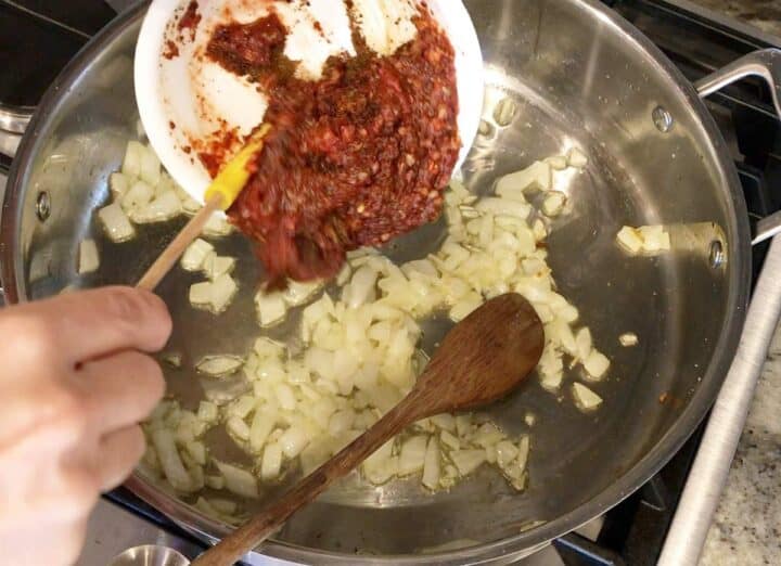Adding the seasoning paste to the pan.