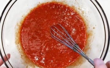 Mixing tomato paste into the eggs.