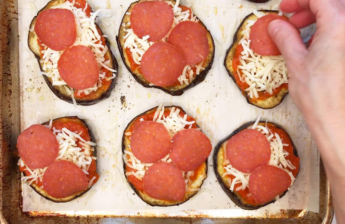 Adding toppings to the pizza.