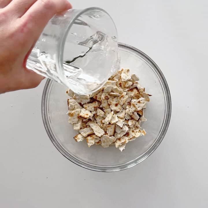 Adding water to the matzo pieces.