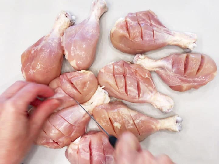 Cutting slits in the chicken.