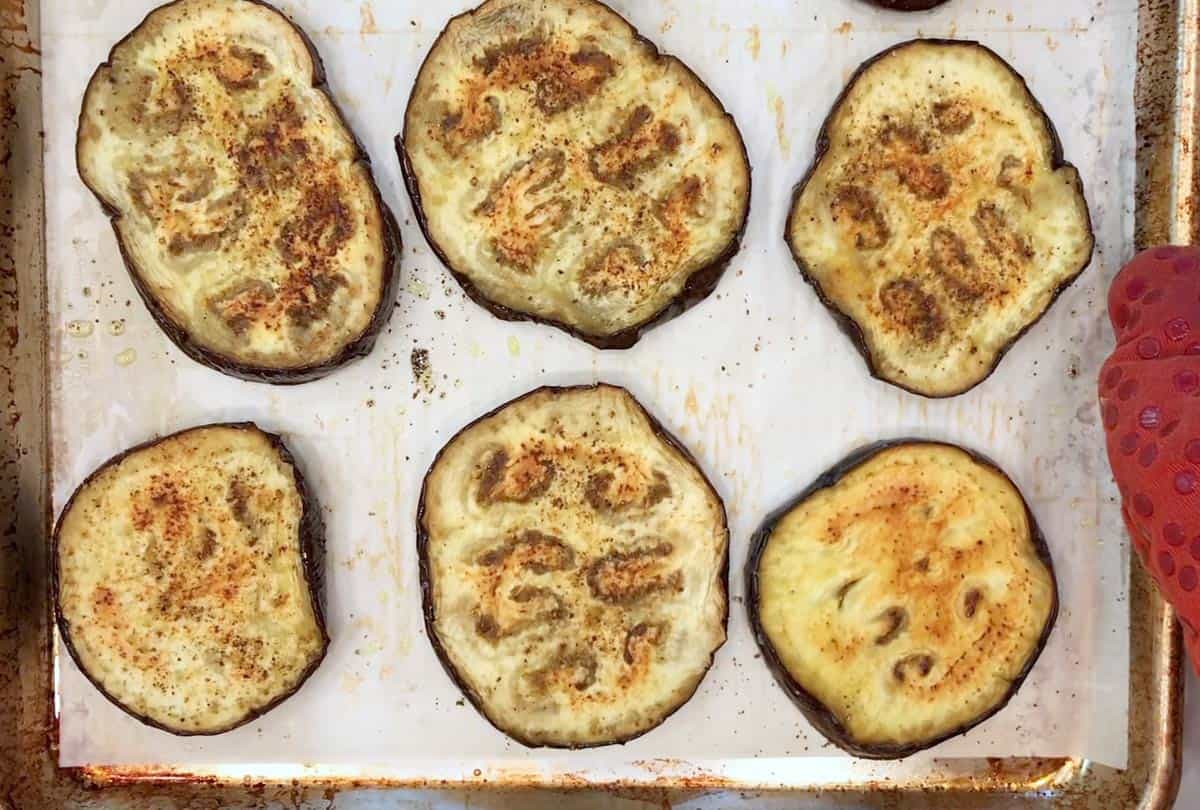 Baked eggplant slices on a baking sheet.