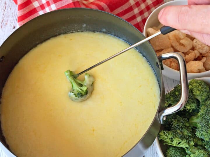 Broccoli is dipped into the fondue.