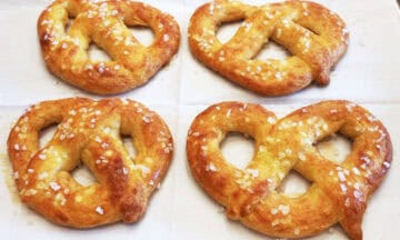 Four keto pretzels are ready on a baking sheet.