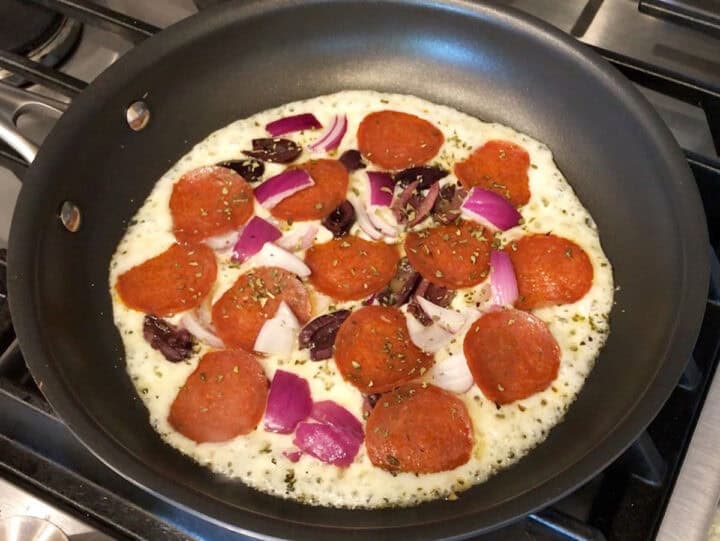Toppings were added to the pizza.