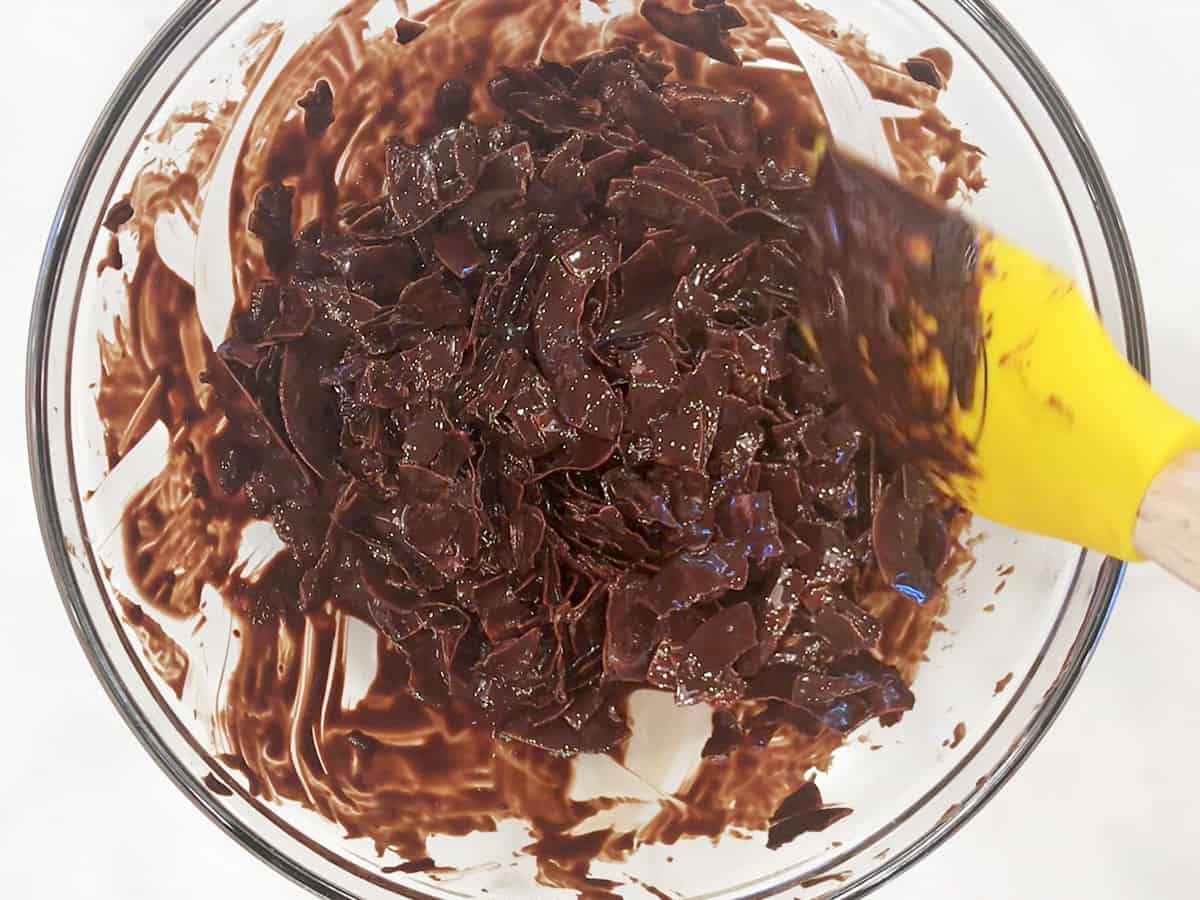 Mixing the coconut flakes into the melted chocolate.