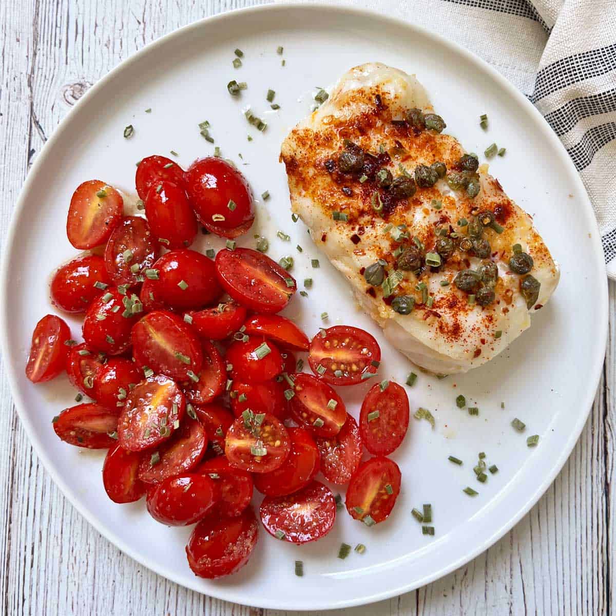Cod is served with cherry tomato salad.