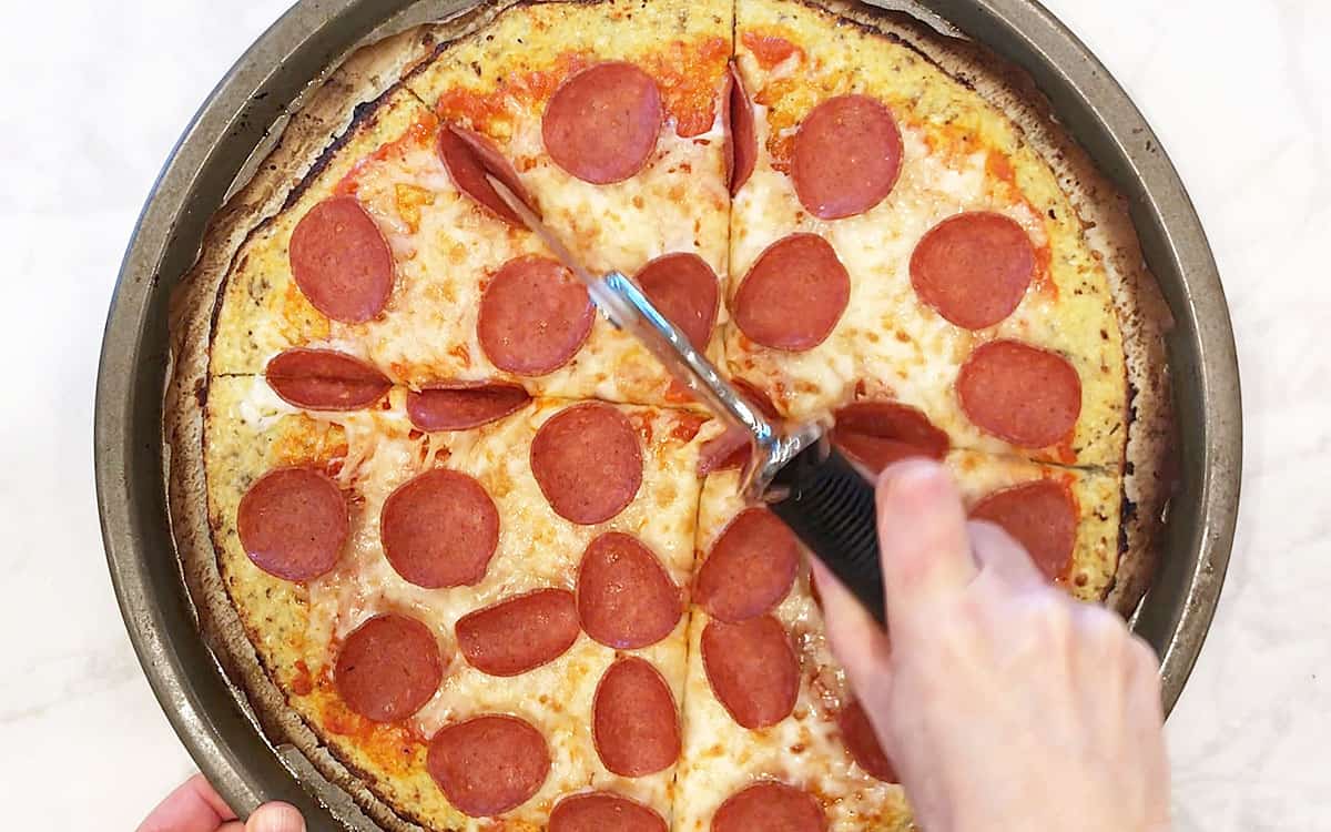 Cutting the pizza into slices.