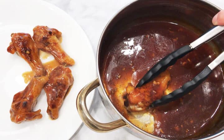 Dipping the wings in teriyaki sauce.