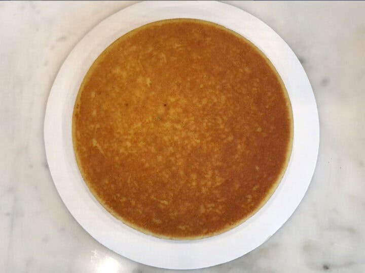 The first layer of the cake was placed on a cake board.