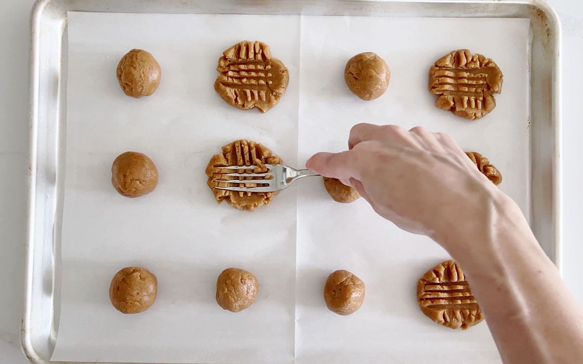 Flattening the cookies with the back of a fork.