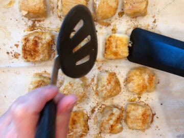 Flipping the chicken nuggets in the pan.