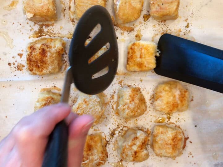 Flipping the chicken nuggets in the pan.