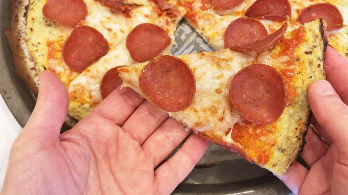 Holding a slice of pizza.