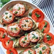 Pesto chicken is served in a white baking dish.