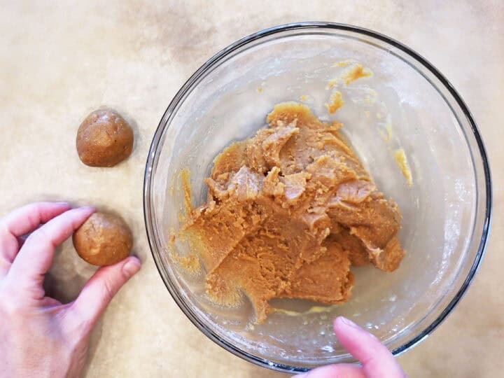 Placing the dough balls on the cookie sheet.