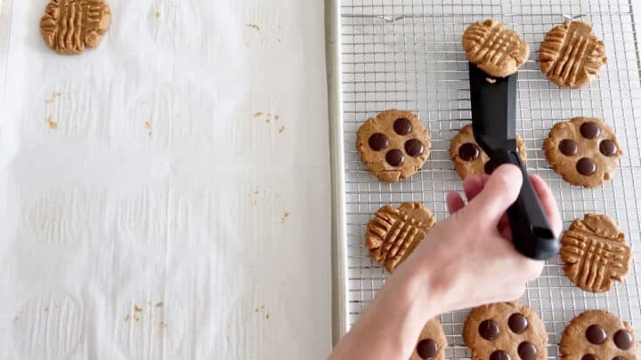 Transferring the cookies from the pan to the cooling rack.