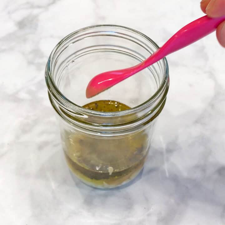 Adding the dressing ingredients to a jar.