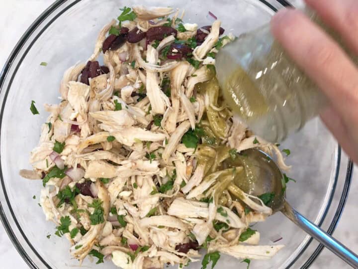 Adding the dressing to the salad.