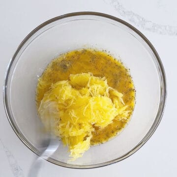 Adding spaghetti squash to the egg mixture.