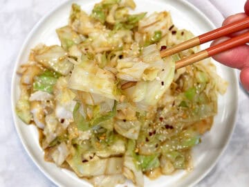 Cabbage stir fry is served with chopsticks.