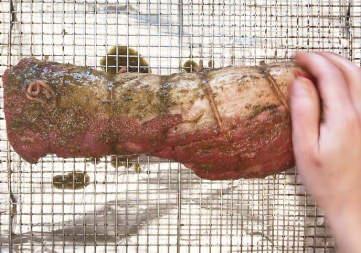 Coating the meat in the rub.