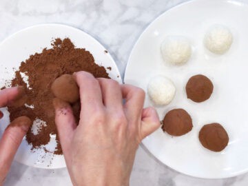 Coating a bite in cocoa powder.
