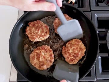Cooking the burgers in the skillet.