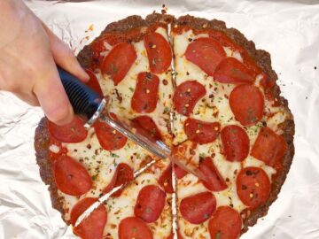 Cutting the meatzza into triangles.