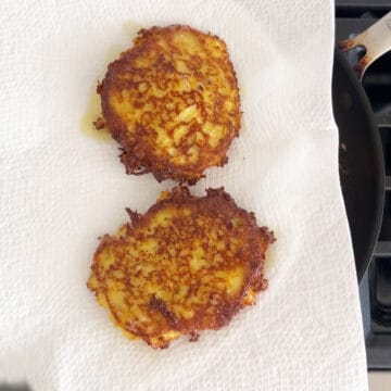 Draining the fritters on paper towels.