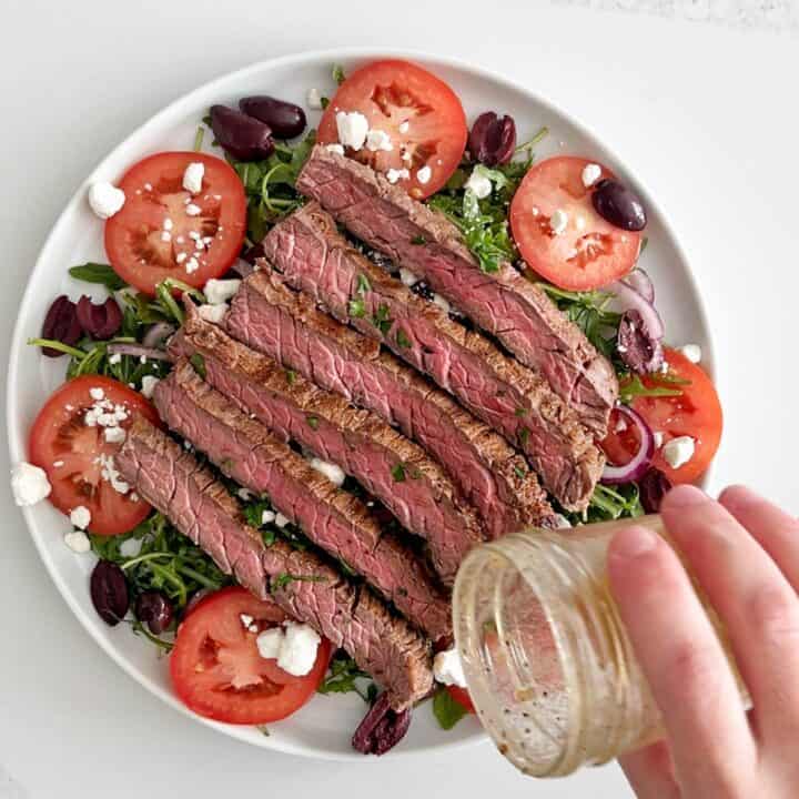 Drizzling the salad with the remaining dressing.