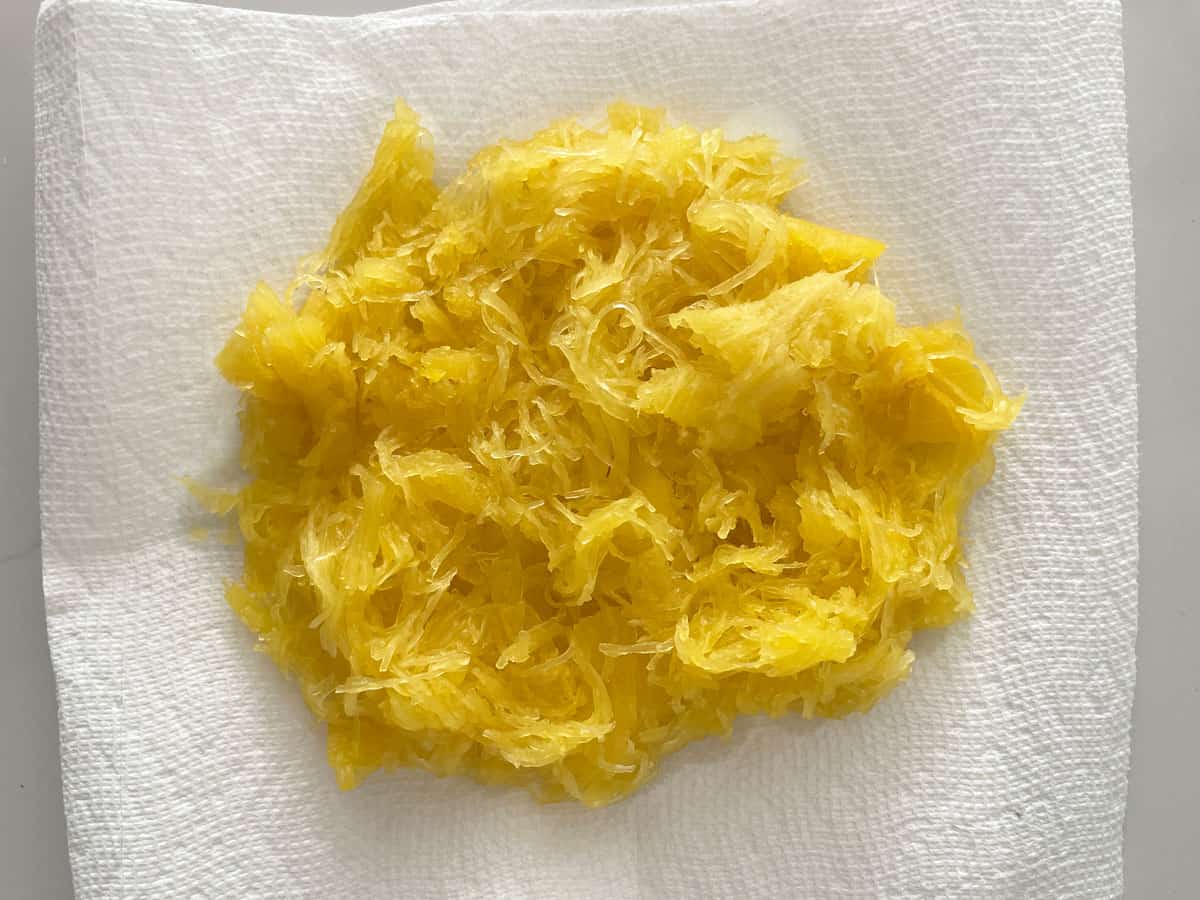 Draining the cooked spaghetti squash on paper towels.