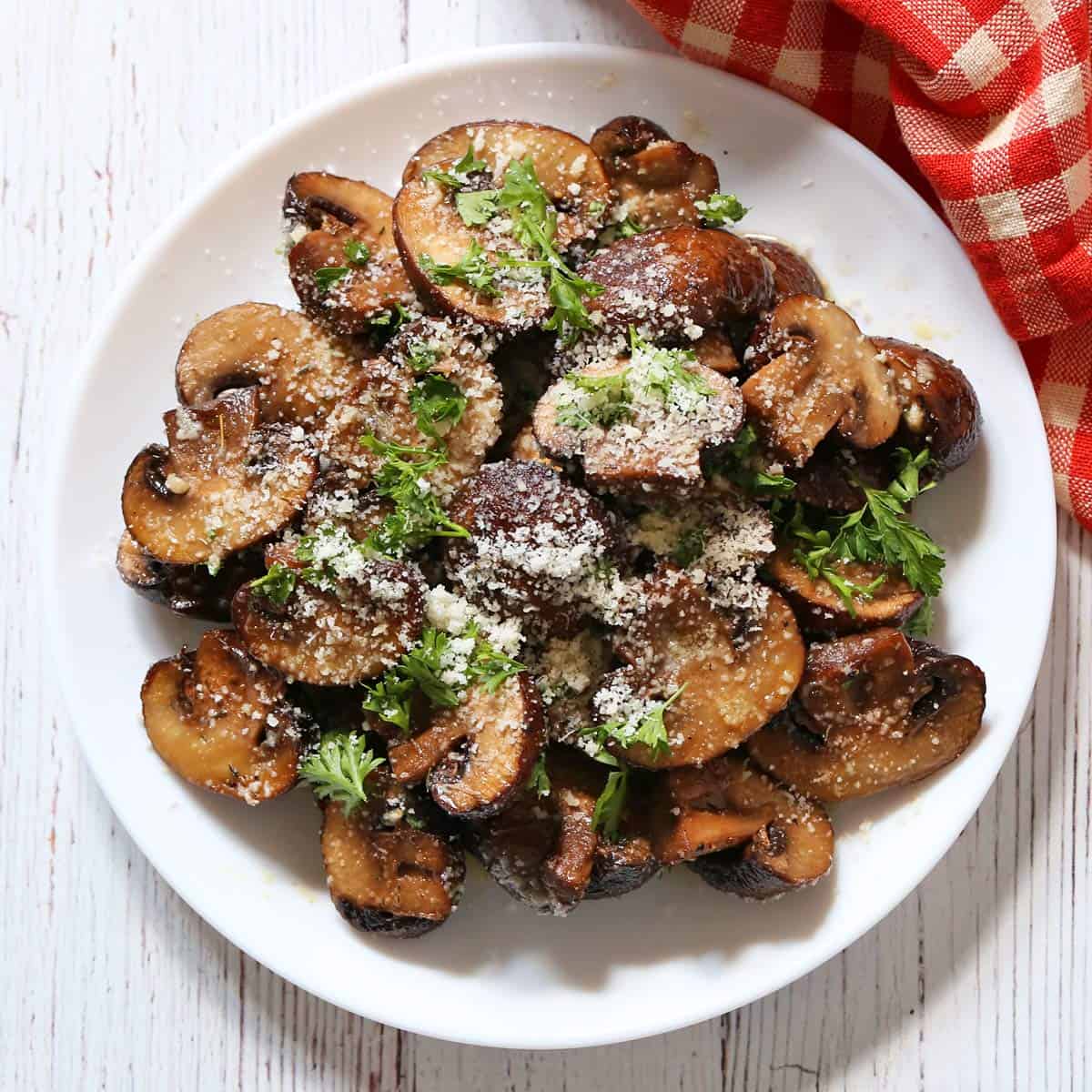 Roasted mushrooms are topped with parsley and parmesan.