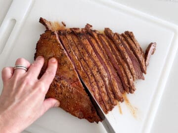Slicing the steak with a chef's knife.