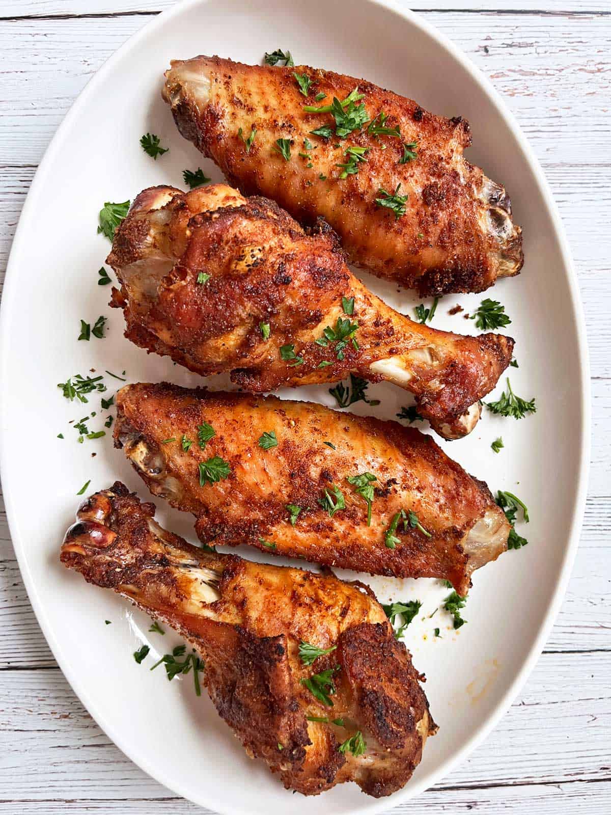 Baked turkey wings are served on a white platter.