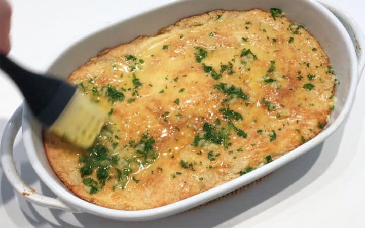 Brushing the bread with the butter mixture.