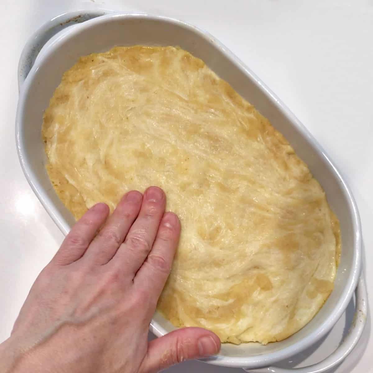 Spreading the dough in the pan.