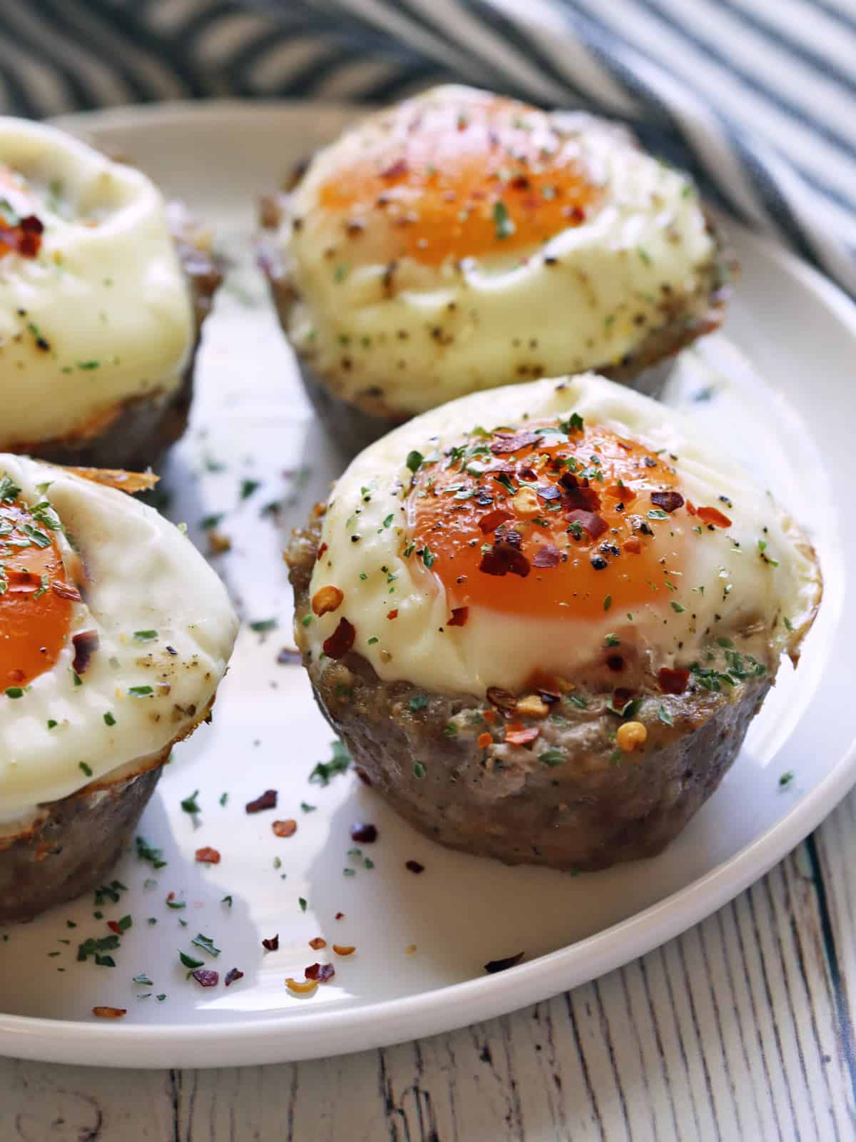 Sausage egg muffins are served on a white plate.
