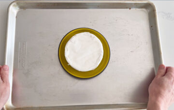 Placing the brie in a baking dish.