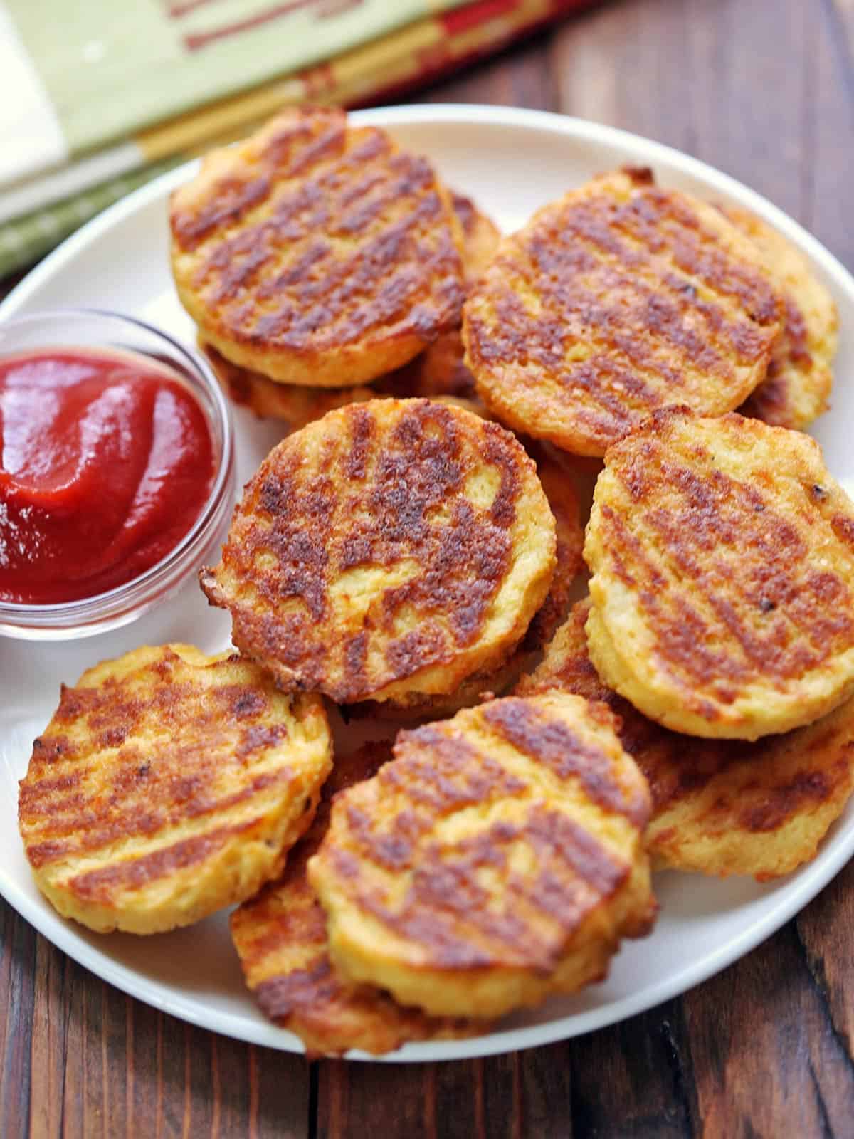 Cauliflower bites are served with ketchup for dipping.