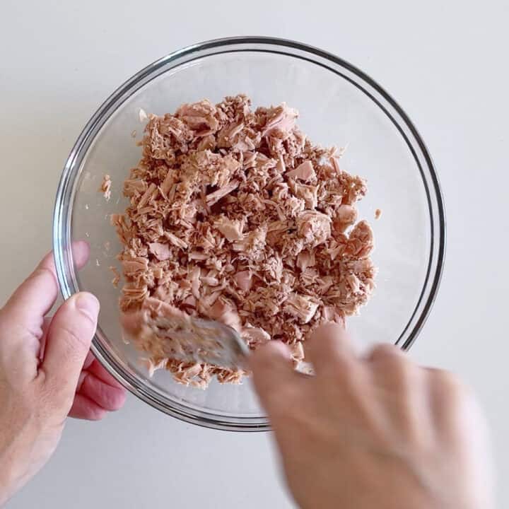 Flaking the tuna with a fork.