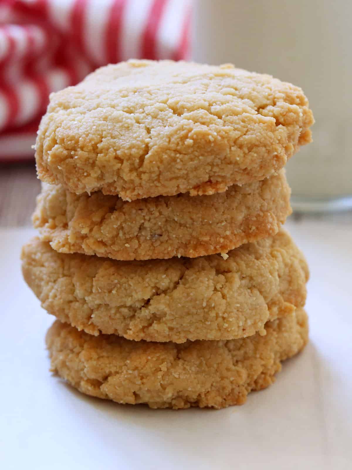 Four keto shortbread cookies are stacked on a plate.